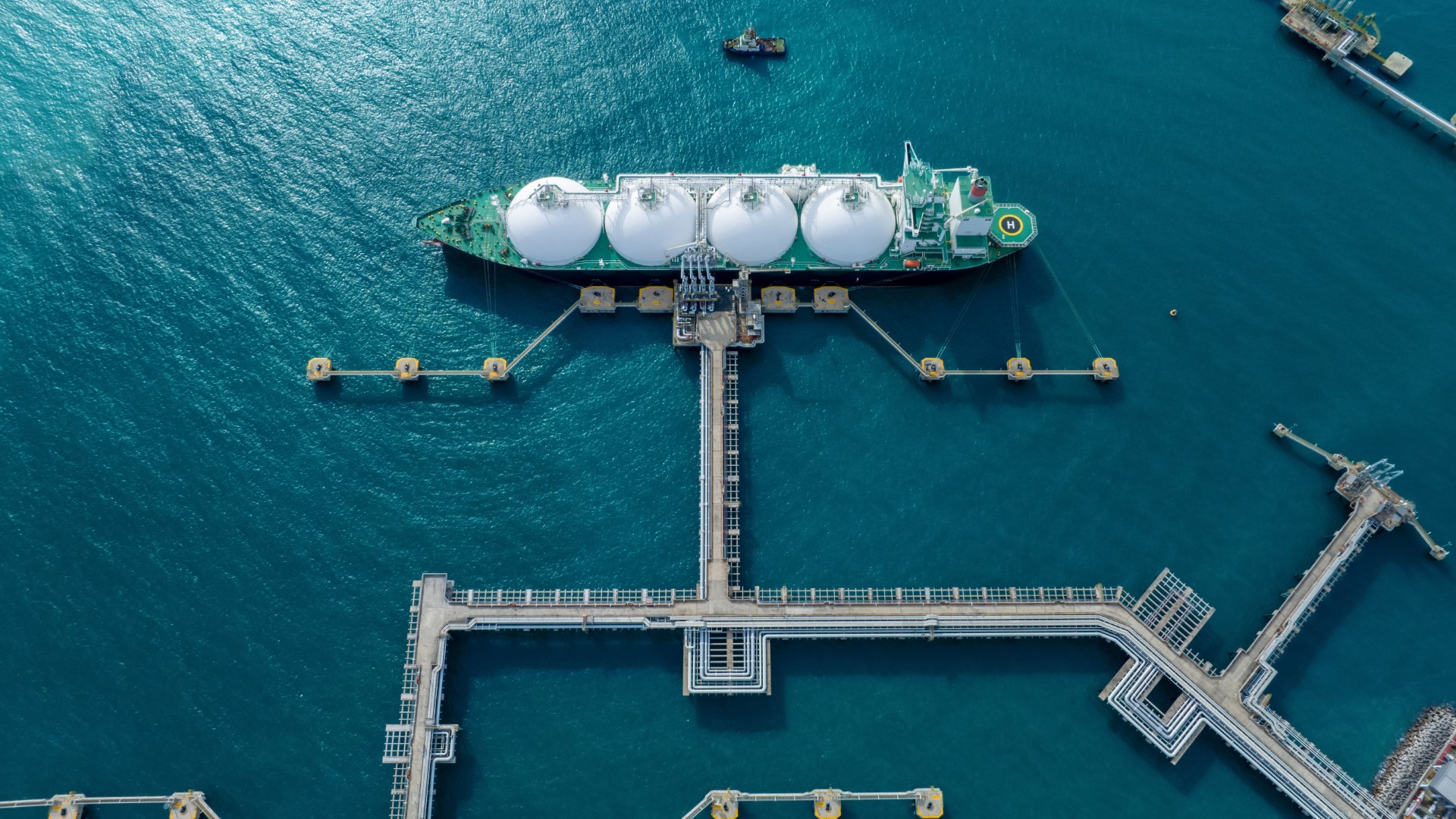LNG (Liquified Natural Gas) tanker anchored in Gas terminal gas tanks for storage. Oil Crude Gas Tanker Ship. LPG at Tanker Bay Petroleum Chemical or Methane freighter export import transportation and logistics
